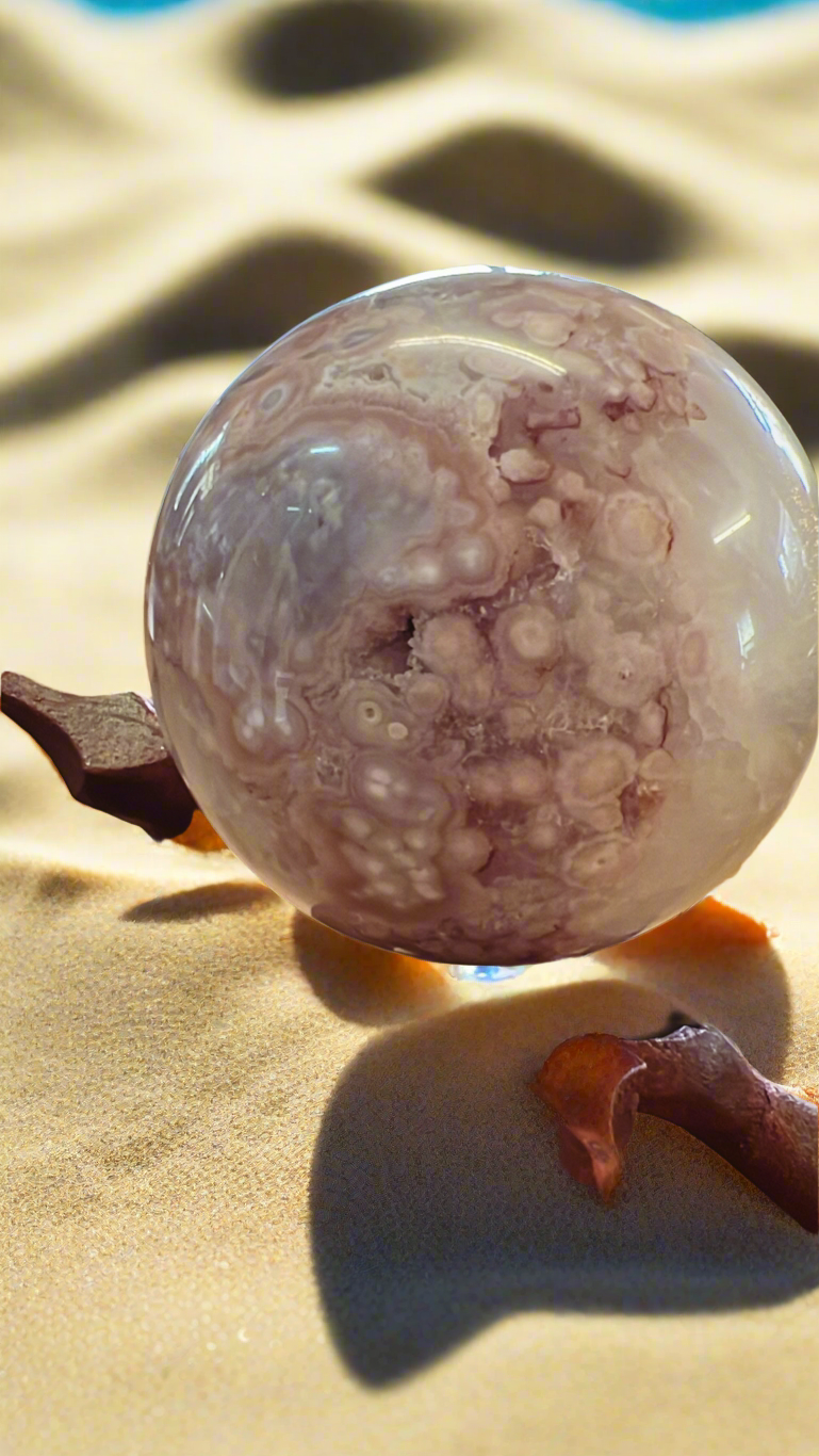 Flower agate sphere on wooden stand