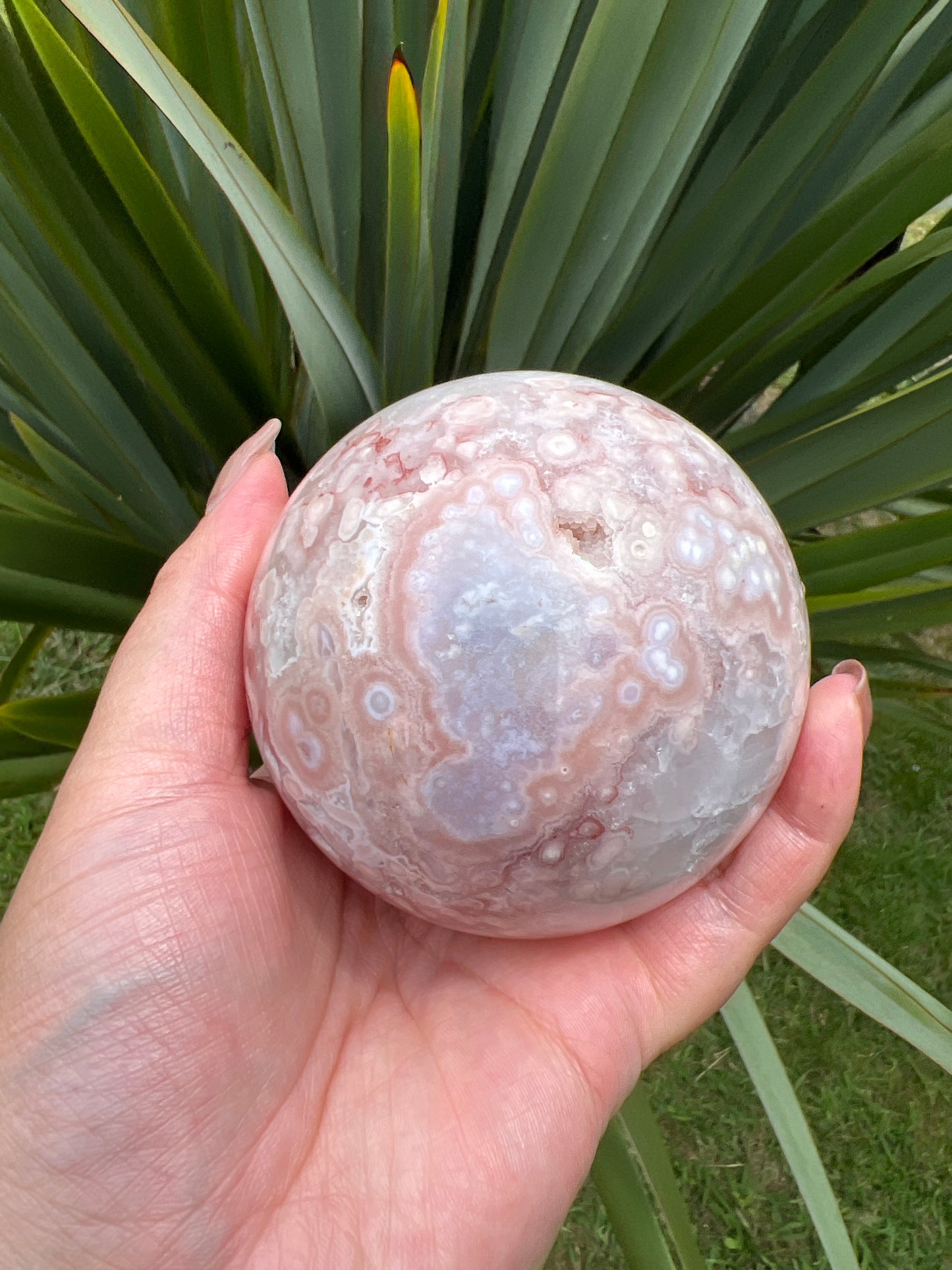 Flower agate sphere on wooden stand